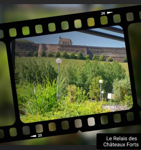 a view of a field with a building in the background at Le Relais Des Chateaux Forts in Bitche