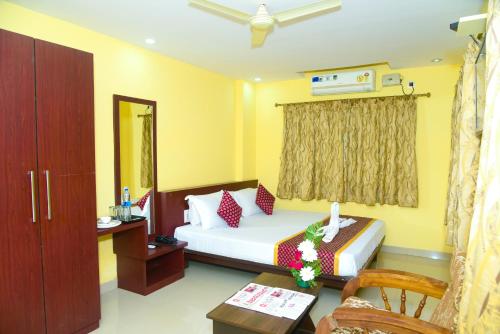 1 dormitorio con 1 cama, 1 mesa y 1 silla en Grand Plaza, en Dharwad