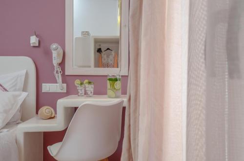 a bathroom with a white shower curtain and a sink at Panormos Hotel and Studios in Naxos Chora