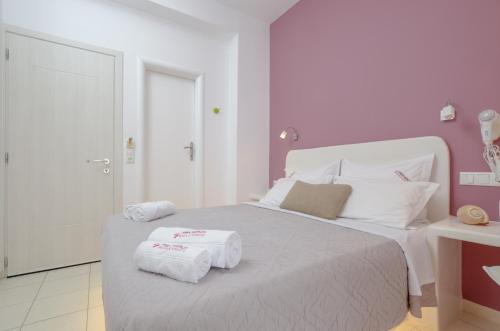 a bedroom with a bed with two towels on it at Panormos Hotel and Studios in Naxos Chora