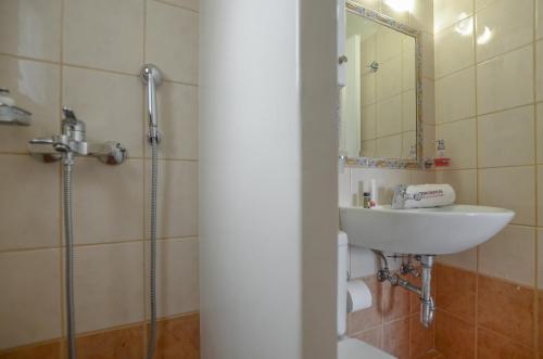 a bathroom with a sink and a shower with a mirror at Panormos Hotel and Studios in Naxos Chora