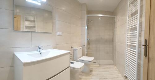 a white bathroom with a sink and a toilet at Casa Filomena apartamento de diseño en St. Joan de les Abadesses in Sant Joan de les Abadesses