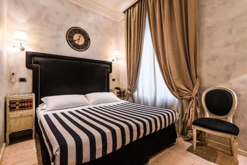 ローマにあるMDM Guesthouseのベッドルーム1室(ベッド1台、壁掛け時計付)