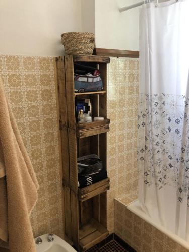 - une salle de bains avec une étagère en bois à côté d'une douche dans l'établissement Villa provençale – grand jardin - 2 chambres, à Bandol