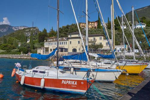 a group of boats docked in the water in a harbor at Hotel Paradiso Conca d'Oro in Nago-Torbole
