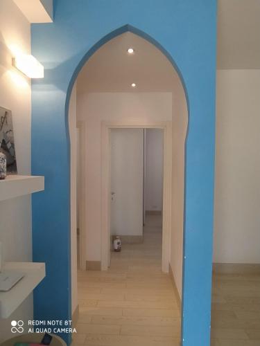 une arche dans un couloir avec un mur bleu dans l'établissement Casa Vacanze Controvento, à San Vito Lo Capo