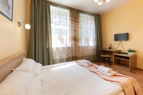 a bedroom with a large white bed with a window at Spare Hotel and Bowling in Riga