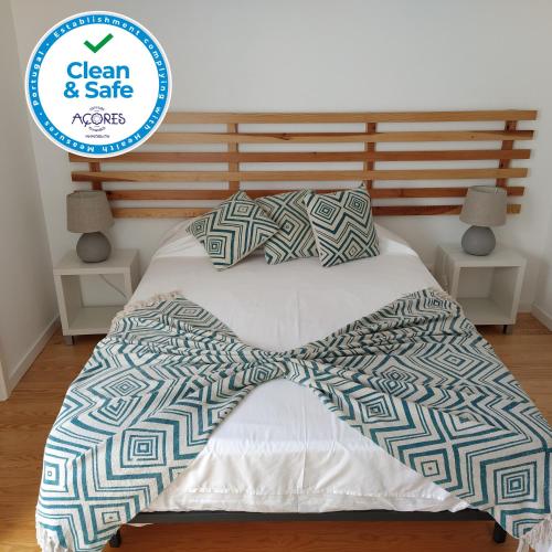 a bed with a comforter and pillows on it at City Center House in Ponta Delgada