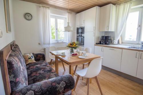 een woonkamer met een tafel en een keuken bij Haus Hirt - Idyllisch wohnen zwischen Augsburg und München in Klosterlechfeld