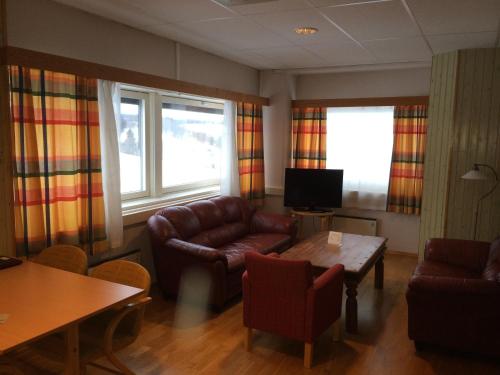 a living room with leather furniture and a table at Vormsund Golf Hotell in Vormsund