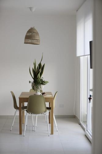 a dining room table with chairs and a plant on it at Cocciu d’amuri in Terrasini