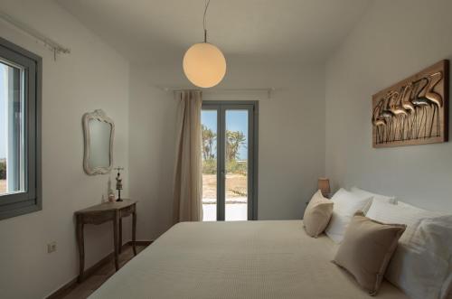 a bedroom with a bed and a mirror and a window at Villa vaya in Naxos Chora