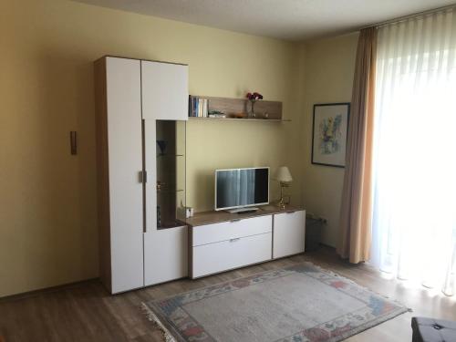 a white cabinet with a television on it in a room at Ferienresidenz Am weißen Regen in Bad Koetzting