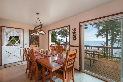a dining room with a table and chairs and a balcony at Pinecone Cabin in Eastsound