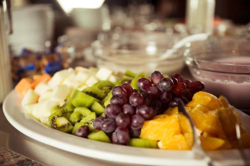a white plate of fruit on a table at Aparthotel Astro - Nichtraucherhotel in Stuttgart