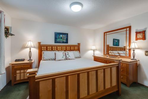 a bedroom with a large wooden bed and a mirror at Pinecone Cabin in Eastsound