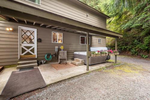 a house with a bed and a patio at Pinecone Cabin in Eastsound