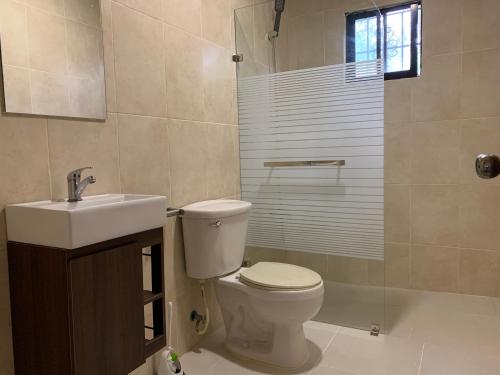 a bathroom with a toilet and a sink and a shower at Caleton Group in Río San Juan