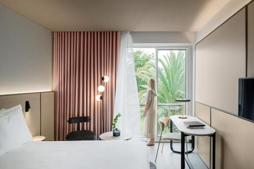 a hotel room with a bed and a desk and a window at Azoris Royal Garden – Leisure & Conference Hotel in Ponta Delgada