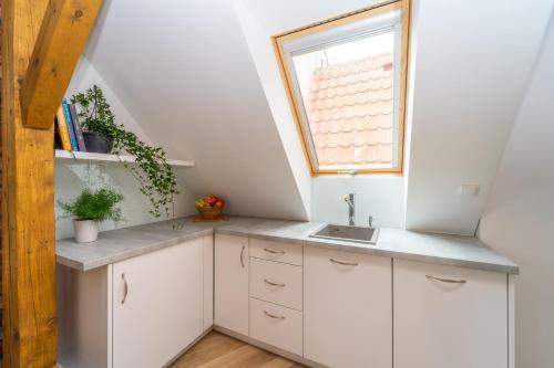 a kitchen with white cabinets and a window at Boutique Gdańsk Apartments in Gdańsk