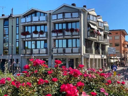 a building with red flowers in front of it at Euro Meublé in Grado