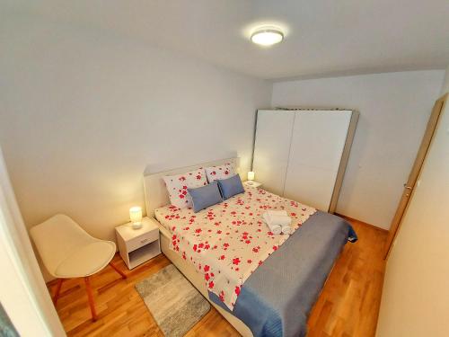 a small bedroom with a bed and a chair at Tusculum apartment Solin in Solin