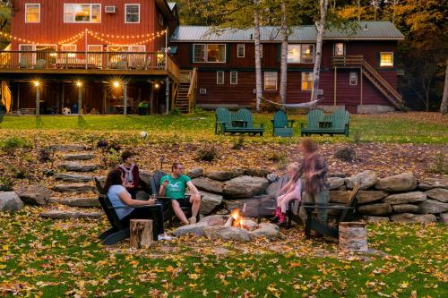 a group of people sitting around a fire pit at Timberholm Inn in Stowe