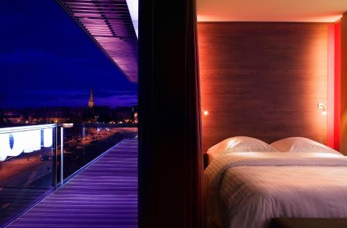 サン・マロにあるオセアニア サン マロのベッド1台、景色を望むバルコニーが備わる客室です。