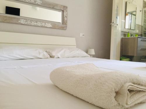 a bedroom with a white bed with a blanket on it at La Vallonea in Casamassella