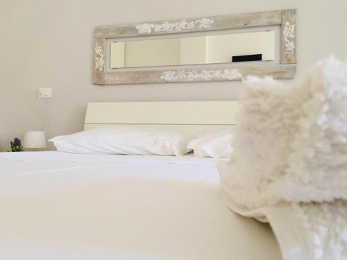 a bedroom with a white bed with a mirror at La Vallonea in Casamassella