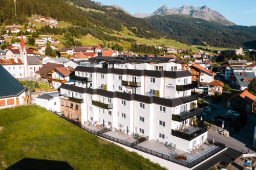 - une vue aérienne sur un bâtiment d'une ville avec des montagnes dans l'établissement Suites by Mein Almhof, à Nauders