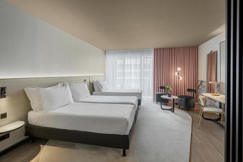 a hotel room with two beds and a desk at Azoris Royal Garden – Leisure & Conference Hotel in Ponta Delgada