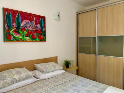 a bedroom with a bed and a painting on the wall at City apartments Bobic in Cavtat