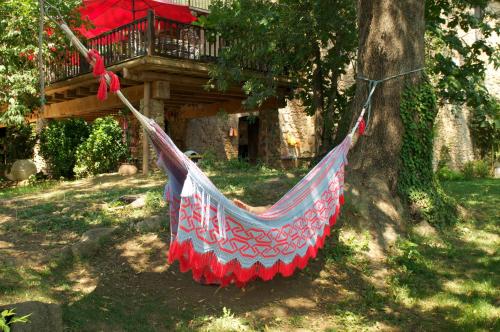 a hammock hanging from a tree in front of a house at Can Portell by 123ole, B&B - Casa Rural in Sant Andreu del Terri