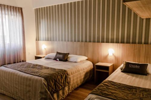 Teutônia的住宿－Hotel União，酒店客房设有两张床和两盏灯。