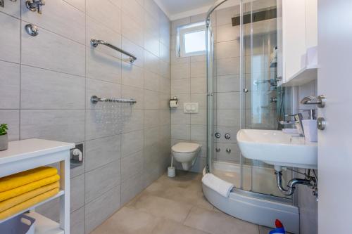 La salle de bains est pourvue d'une douche, d'un lavabo et de toilettes. dans l'établissement NeMo, à Povile