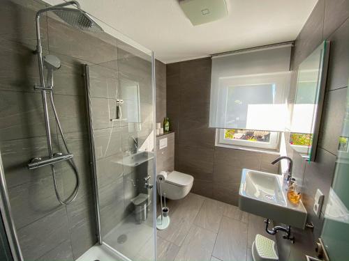 een badkamer met een douche, een wastafel en een toilet bij Apartment Schanzenstraße 690 m ü. M in Winterberg
