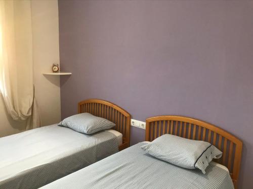 2 Betten in einem Zimmer mit lila Wänden in der Unterkunft Casa Denia in Denia