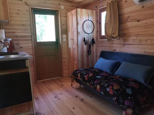 Un dormitorio con una cama en una habitación de madera. en Roulotte la clé du Luberon, en Buoux
