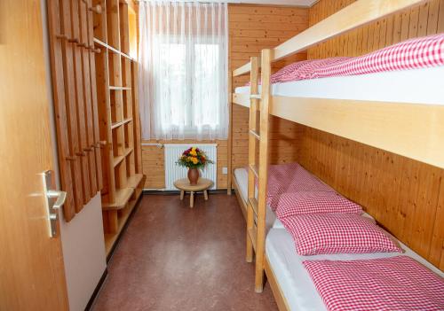 a room with two bunk beds and a window at Erlebacherhus in Lenzerheide