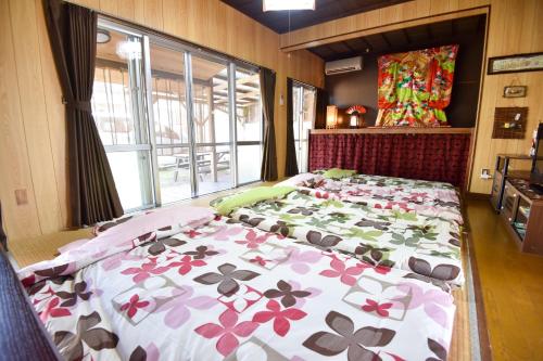 a bedroom with a large bed with flowers on it at Nago - House - Vacation STAY 88505 in Nago