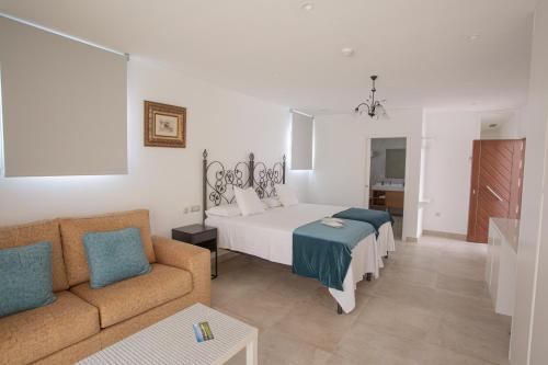 un salon avec un lit et un canapé dans l'établissement El Tesorillo II, à Arcos de la Frontera