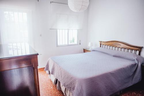 sypialnia z łóżkiem i oknem w obiekcie Casa Cordoba w mieście Chipiona