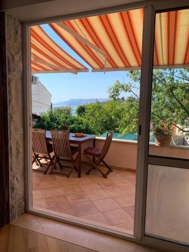 a patio door with a view of a table and chairs at City apartments Bobic in Cavtat