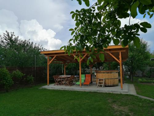 a wooden gazebo with a table and chairs in a yard at Apollo Vendégház in Edelény