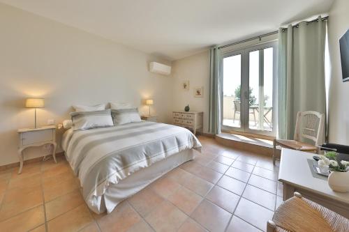 a bedroom with a large bed and a large window at Quintessence Provence in Goult