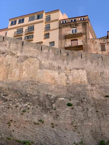 un edificio sentado en la parte superior de una pared en CASA CITADELLA Bonifacio en Bonifacio