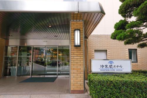 un bâtiment avec un panneau devant lui dans l'établissement Reisenkaku Hotel Ekimae, à Fukuoka