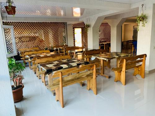 a dining room with wooden tables and benches at Bon Amour in Gagra