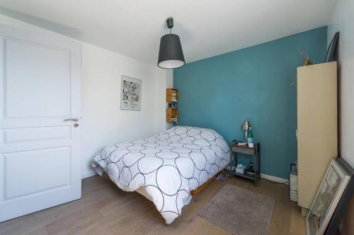 een slaapkamer met een bed en een blauwe muur bij Proche mer, plage et commerces à 500m in La Bernerie-en-Retz